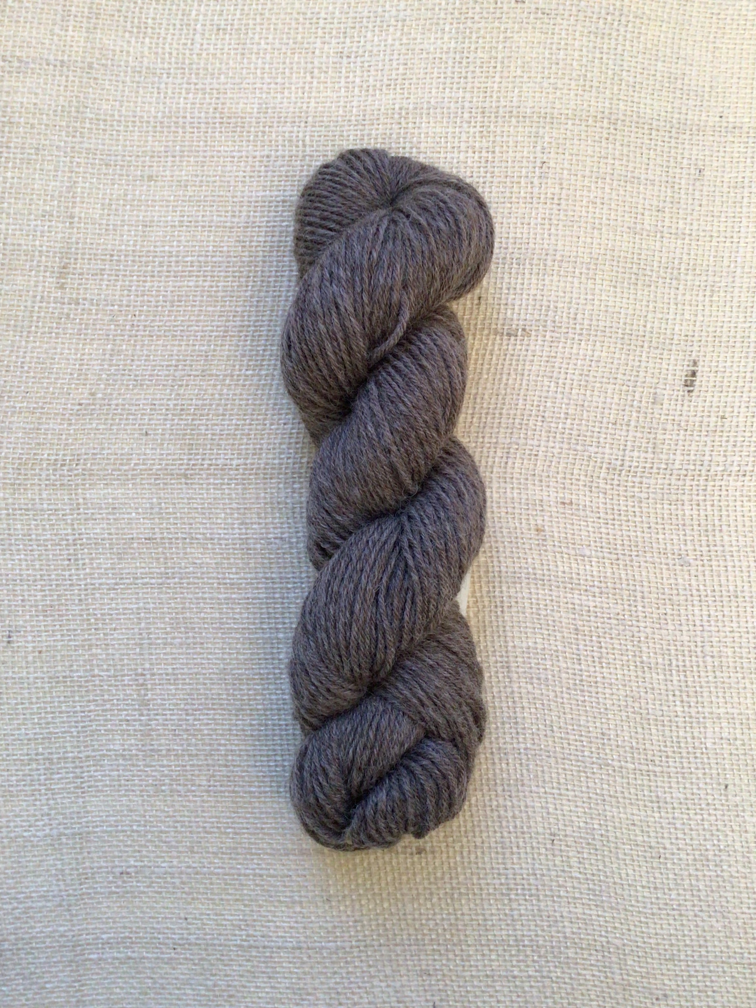 A natural brown yarn on a neutral canvas background