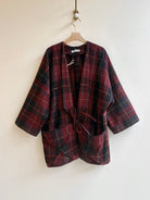 Plaid jacket on a hanger against a plain background