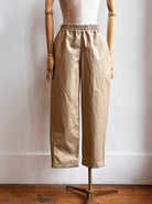 Image of gold waxed cotton jogger-style pants on mannequin