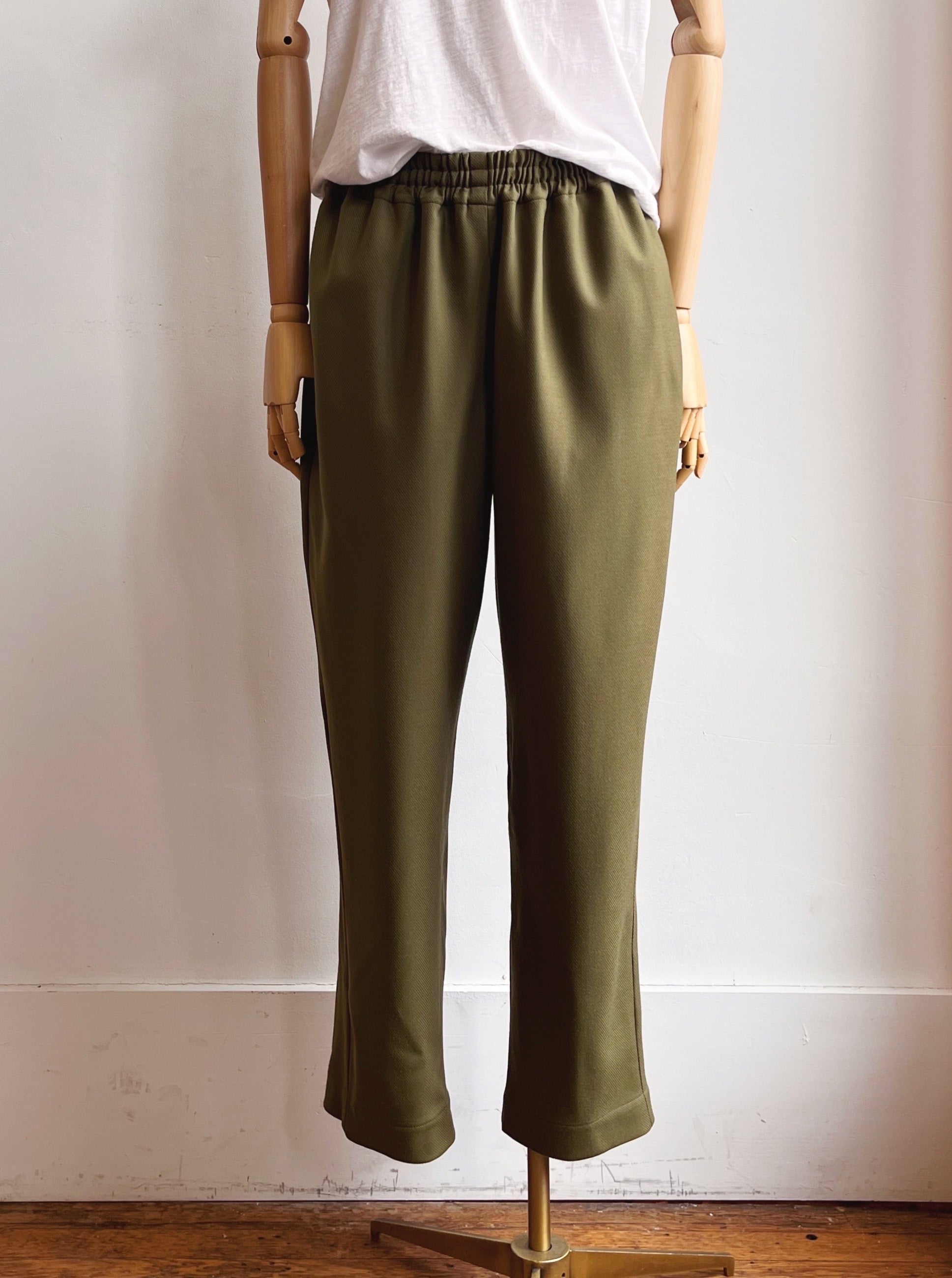 Image of olive green wool twill jogger-style pants on mannequin